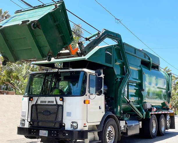 A refuse lorry tipping in a large commercial bin to it's waste carrier.