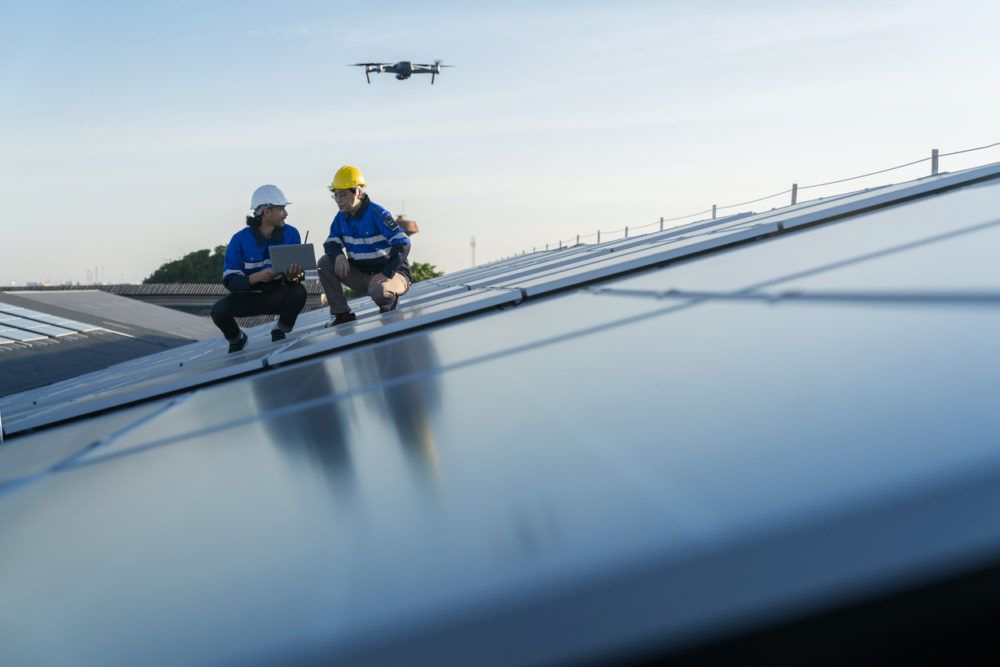 Drone work on the roof being performed by 2 workers