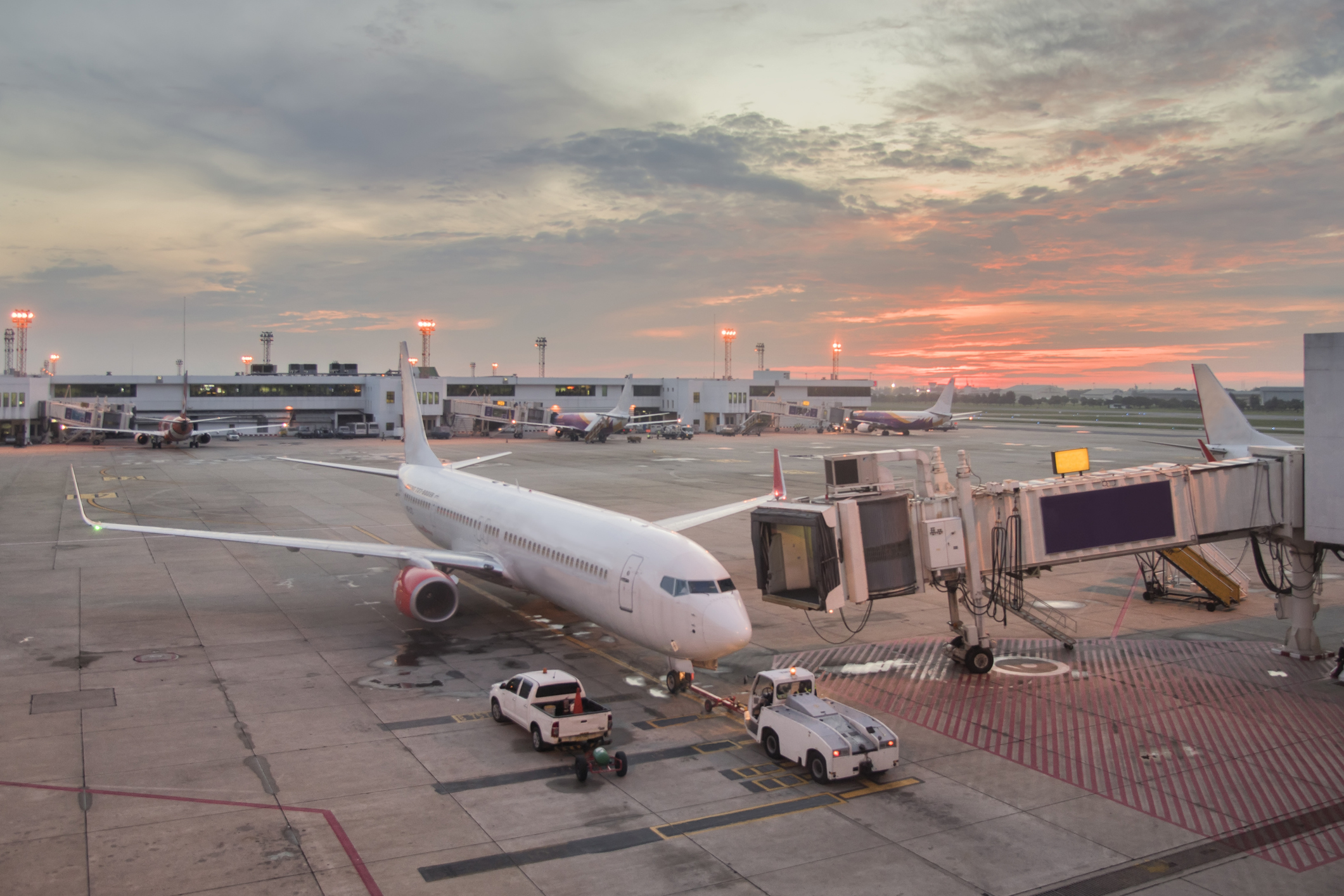 Airplane preparing for takeoff in international airport in morning. Scenic sunrise over airport terminal building