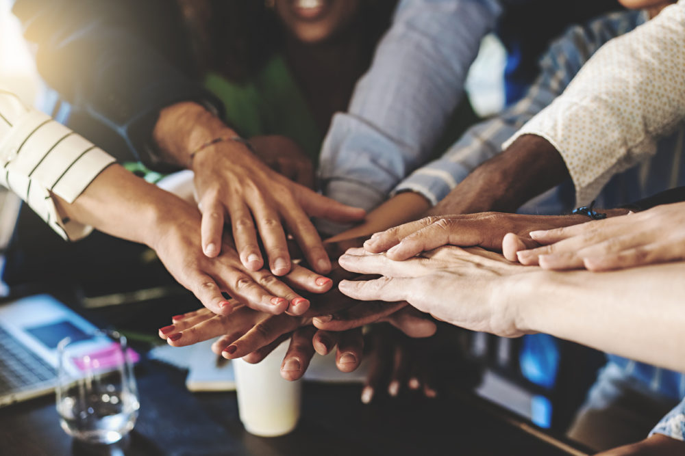 A group of people have their hands together